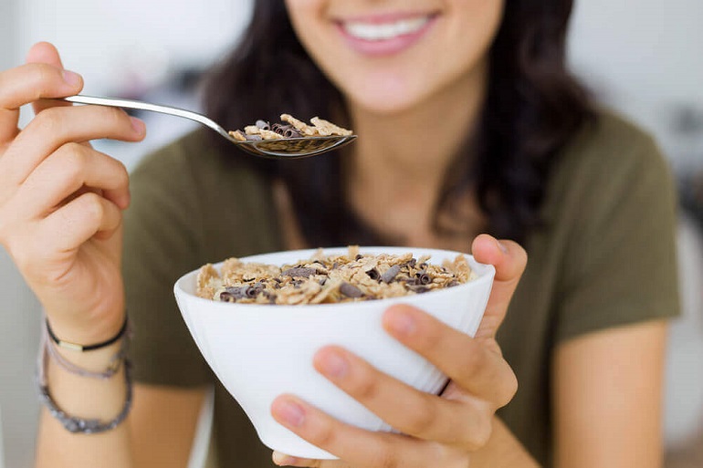 woman eating a bowl of healthy organic  cereal 