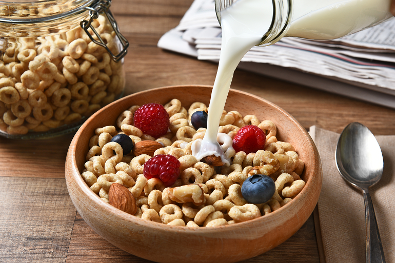 wooden bowl filed with organic cereal on table 