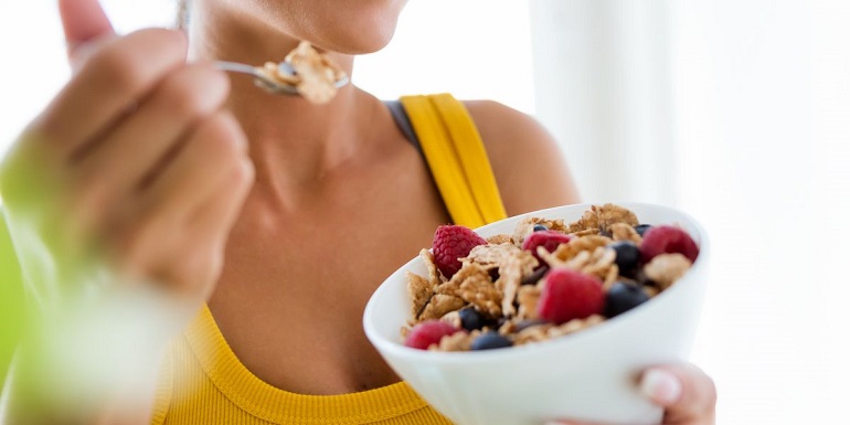 fitness woman eating healthy breakfast cereal 