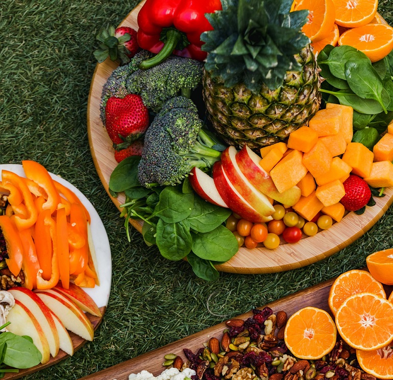 picture of a pile of fruit and vegetables in a plates on a grass