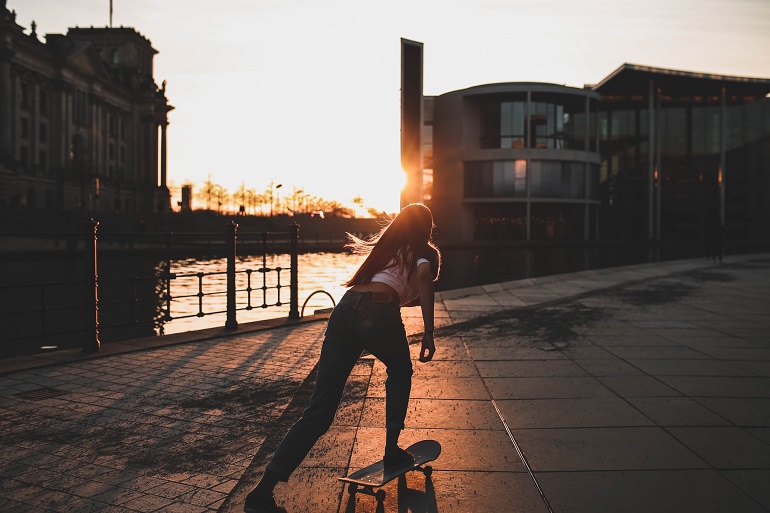 picture of a person driving on a skateboard beside a river