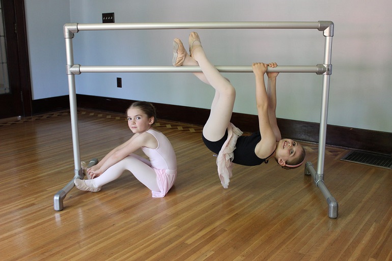 picture of two girls exercising ballet dancing on a portable ballet barre