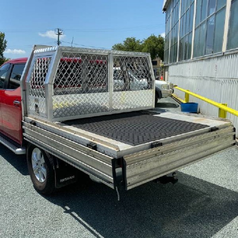 picture of an ute with a gullwing canopy toolbox on a parking lot beside a warehouse