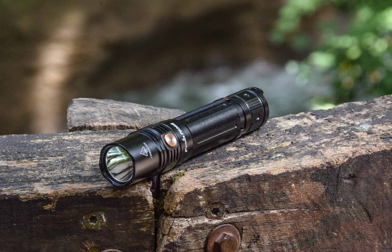 picture of a tactical flashlight on a wooden deck 