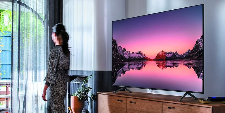 picture of a woman passing by a smart tv 48 inch in a living room 